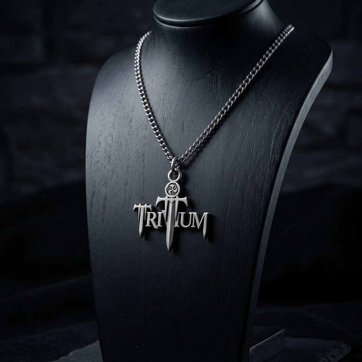 We Rock TRIVIUM logo pendant necklace in silver metal on a black display bust against a dark textured background