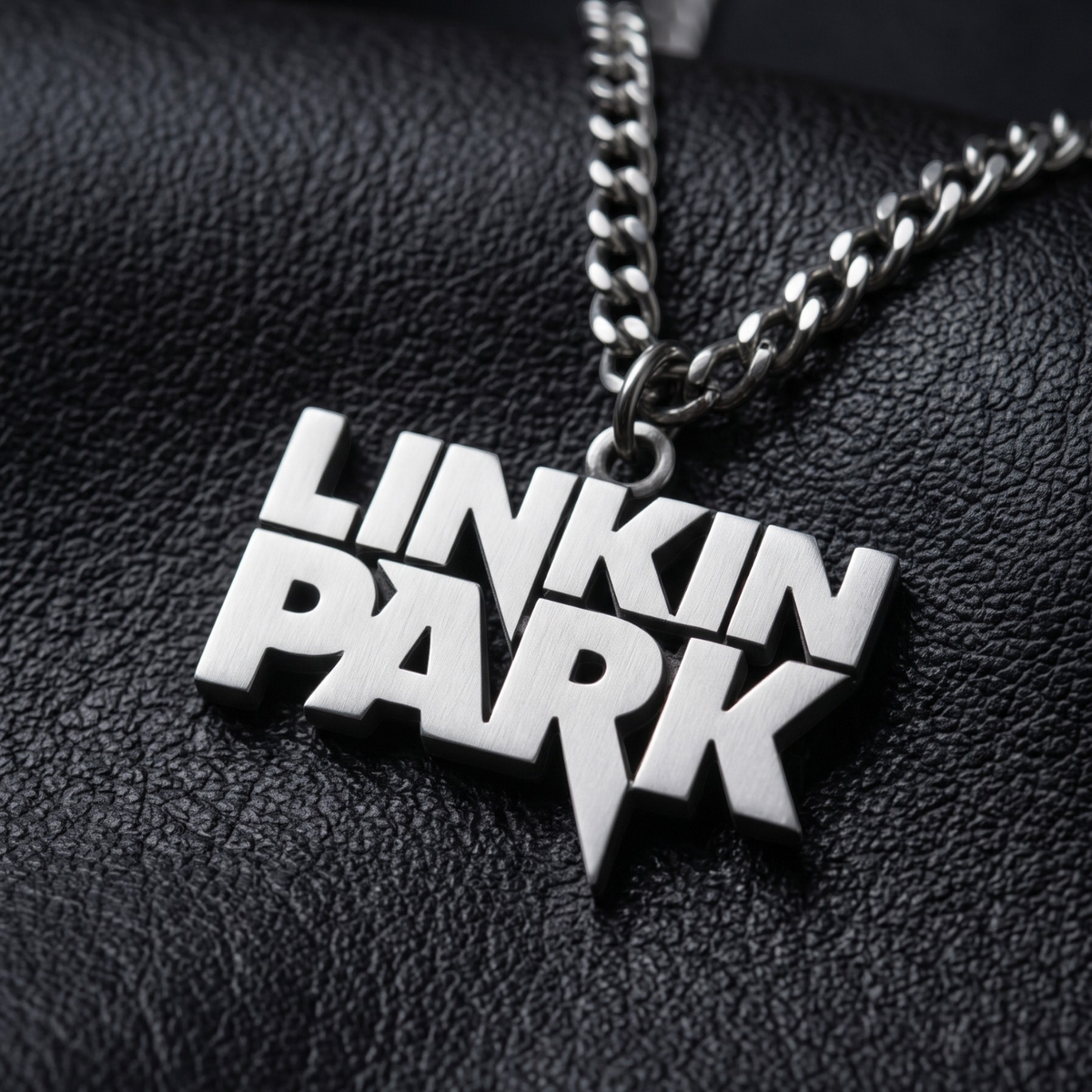 We Rock silver-tone Linkin Park logo pendant necklace on a black textured leather background
